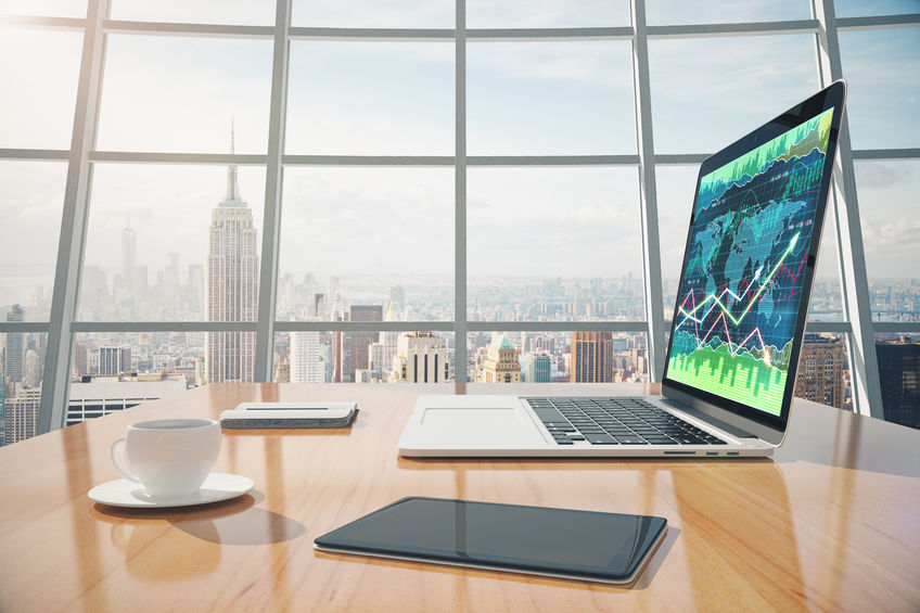 Sunny office with a laptop computer on a wooden desk